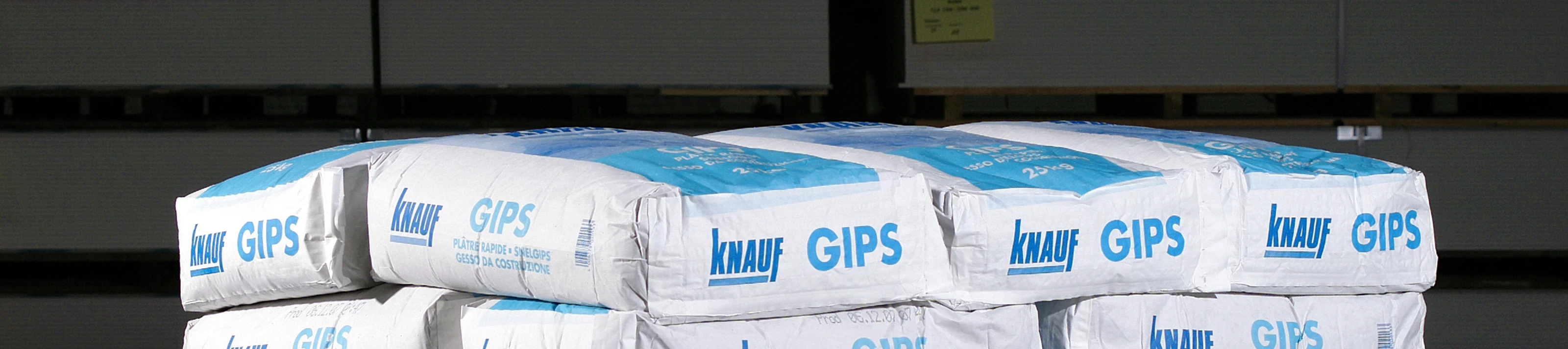 Gips 25kg auf Palette vor dunklem Hintergrund