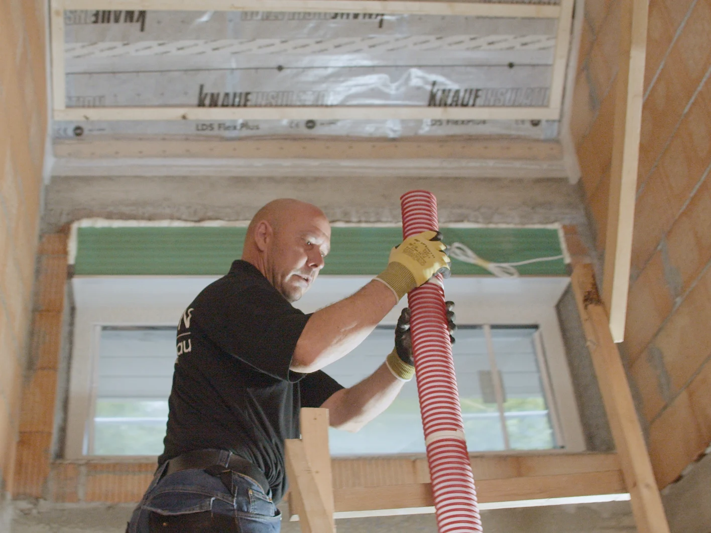 Installer lifting pipe Supafil insulation