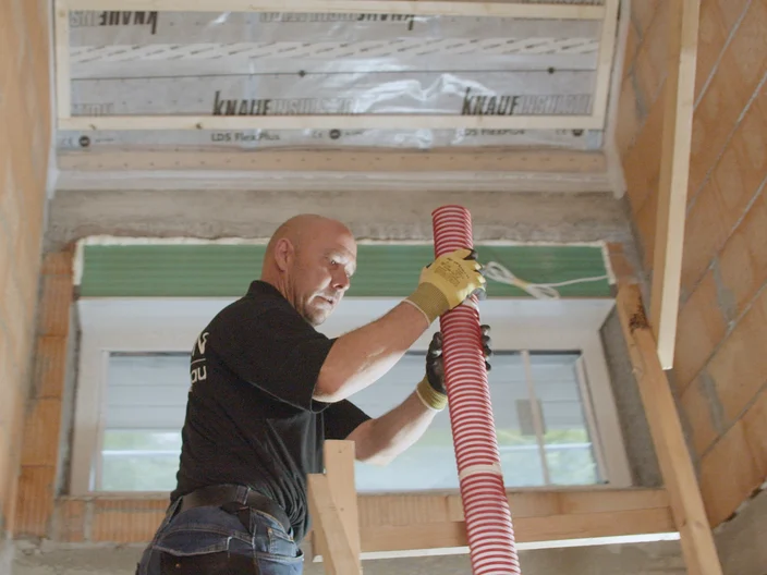 Installer lifting pipe Supafil insulation