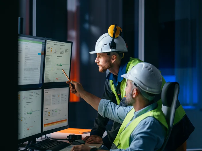 Group of operators control process on product line uses industry 4.0 and digital technology on modern factory. Two engineers follow assembly process uses SCADA system which AI technology and UI 
