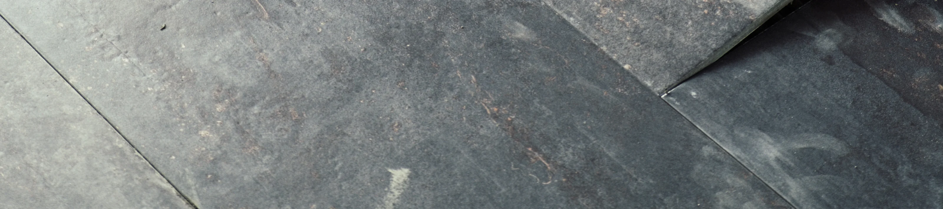 Worker placing ceramic floor tiles on adhesive surface