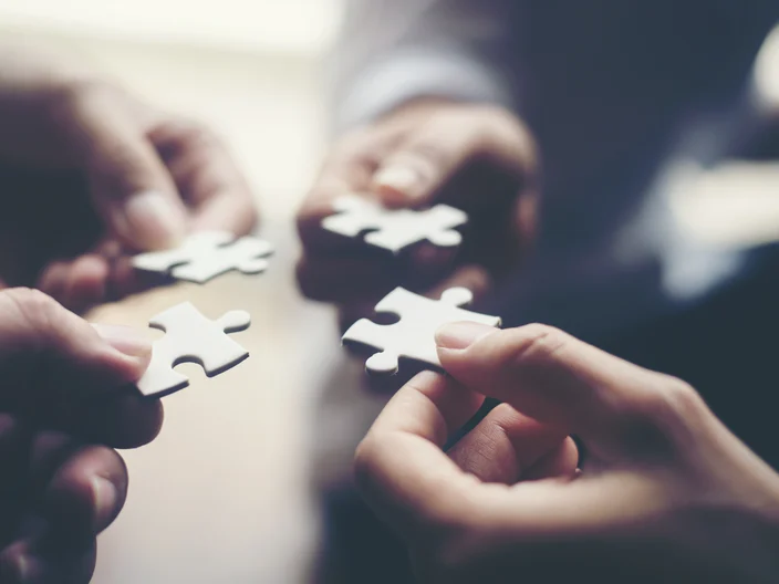 Hand holding jigsaw puzzles, Business partnership concept.