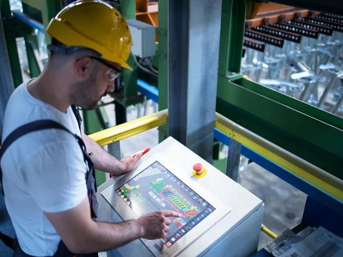 Factory Worker Operating Tablet on Machine
