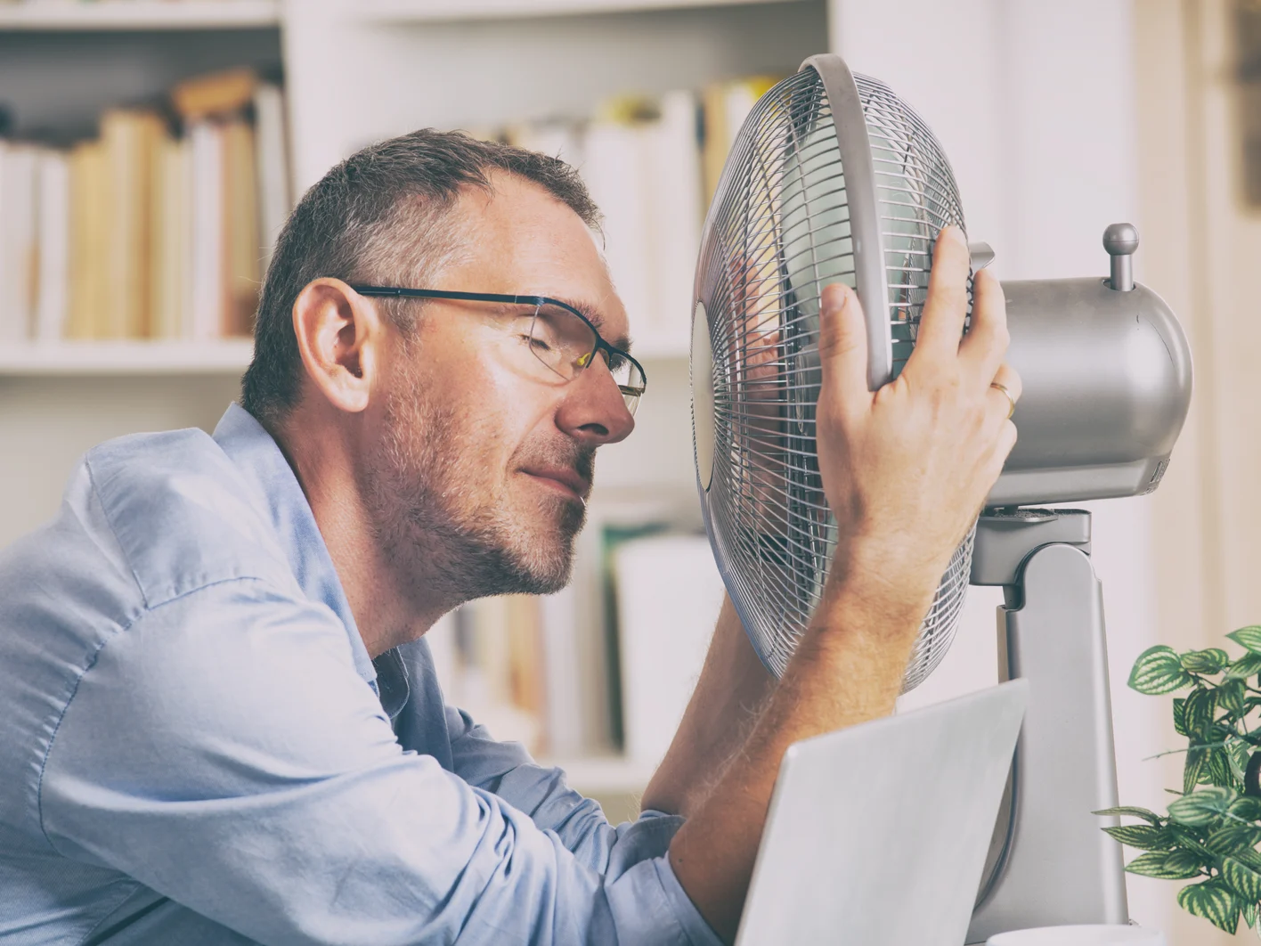 Man suffers from heat in the office or at home