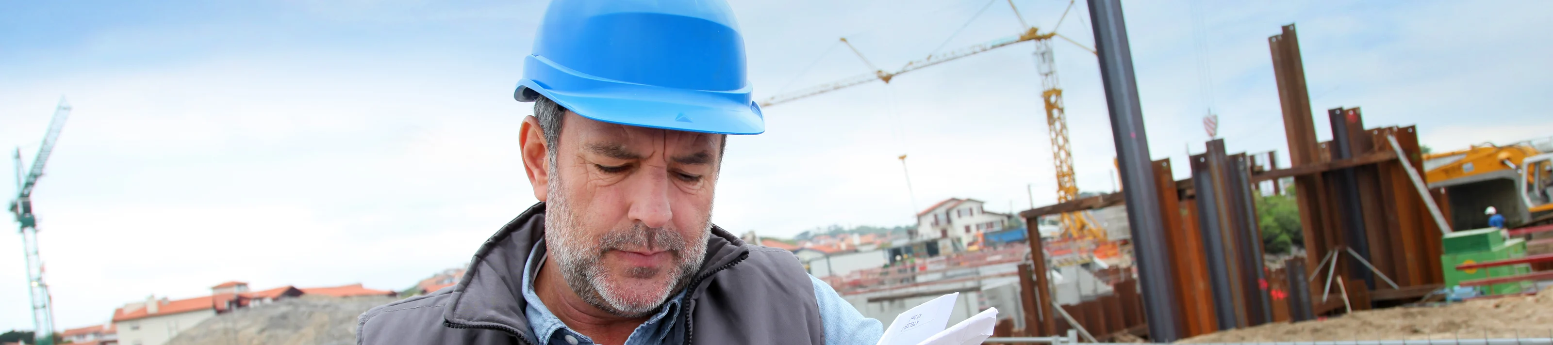 Construction manager controlling building site with plan