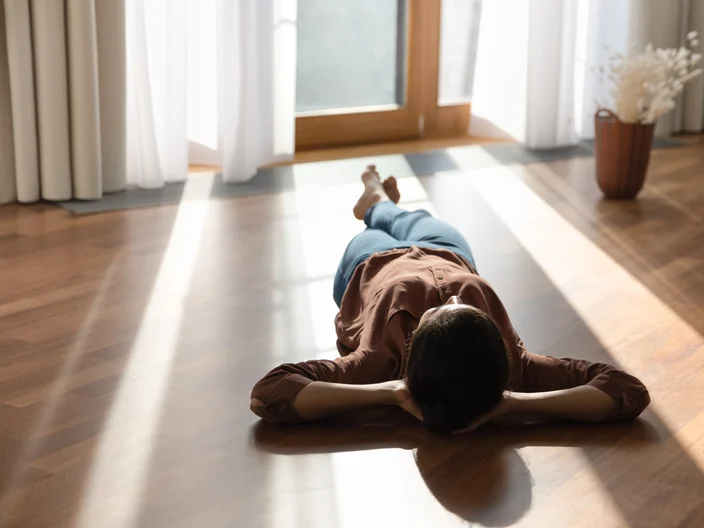 Happy young indian woman lying on warm floor.