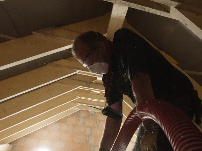 Installer blowing wool Supafil attic closeup