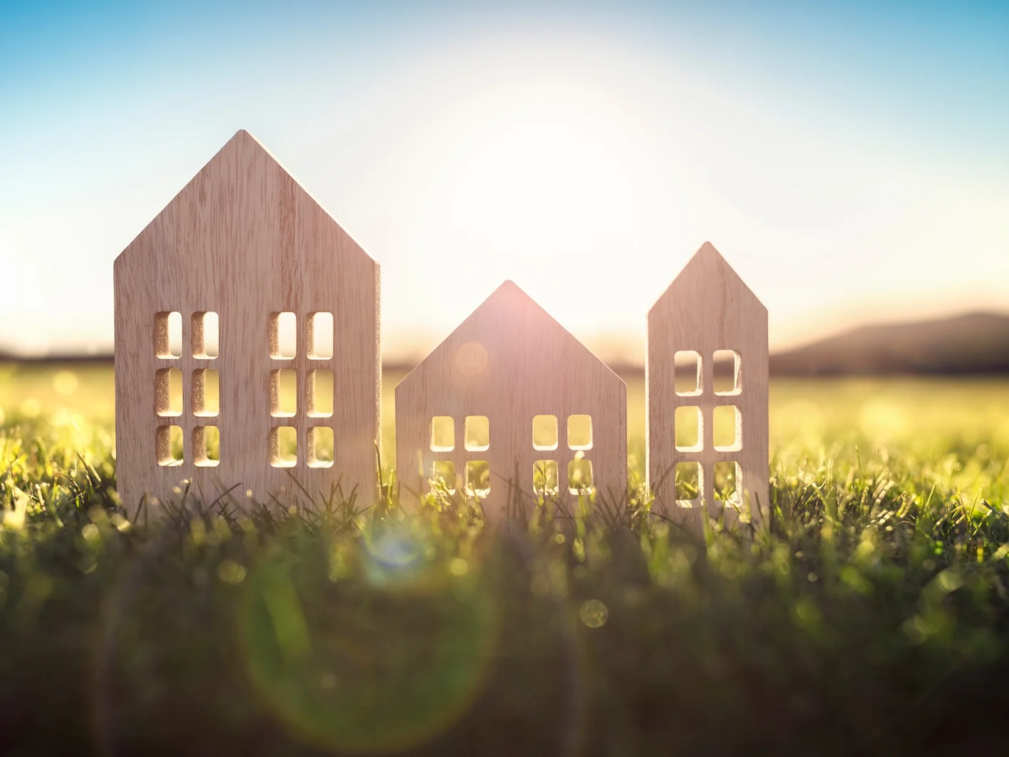 Ecological wood  model house in empty field at sunset