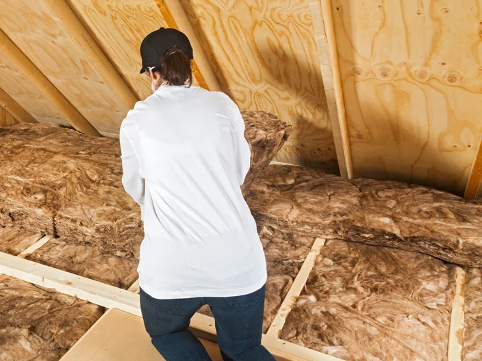 Woman installing insulation in roof