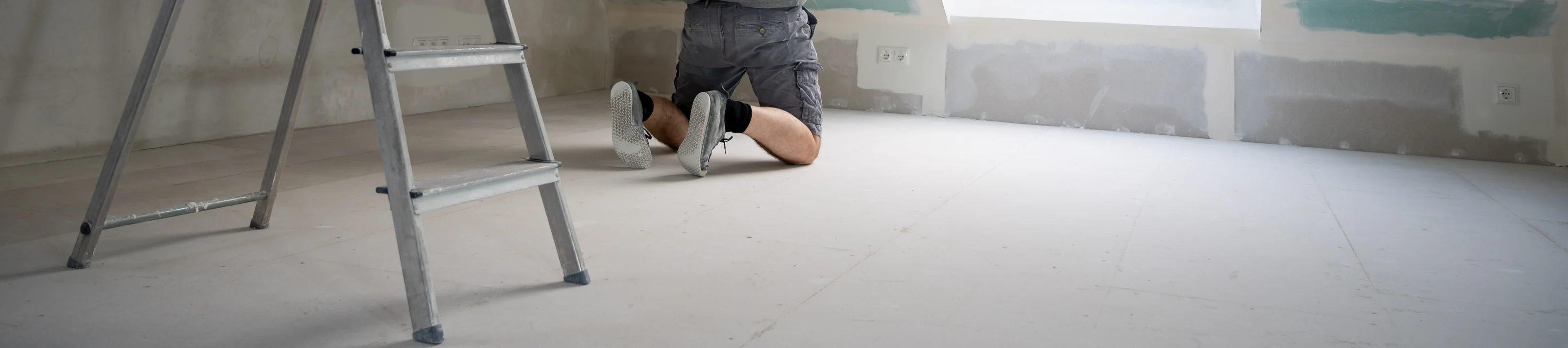 Man plastering drywall in a private house.