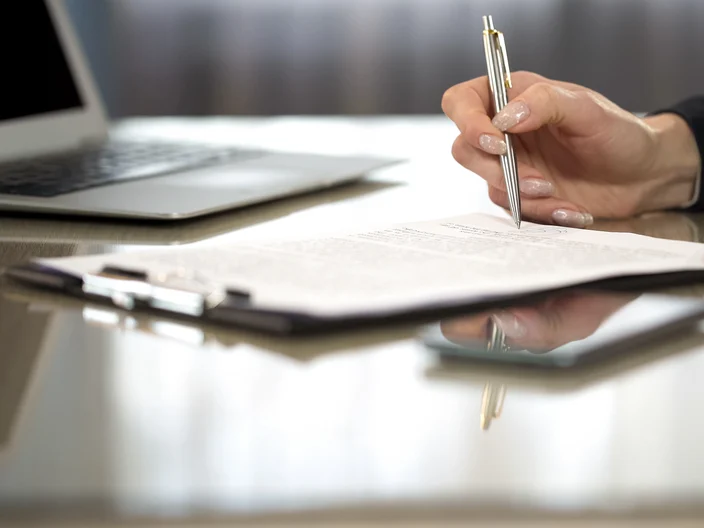 Woman in suit reading terms and conditions of agreement signing contract