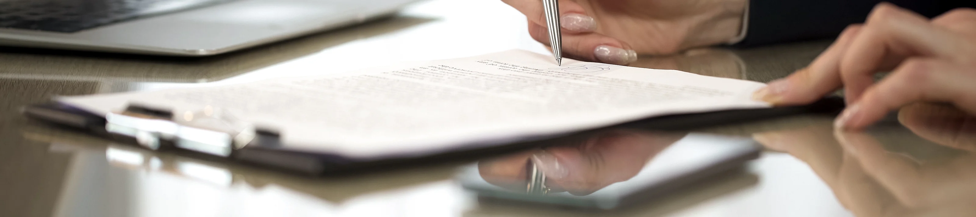 Woman in suit reading terms and conditions of agreement, signing contract