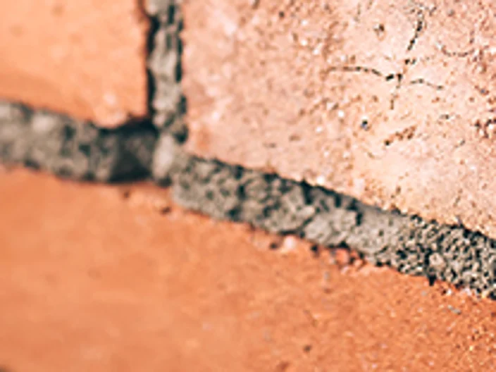 Close up of industrial bricklayer installing bricks on construction site
