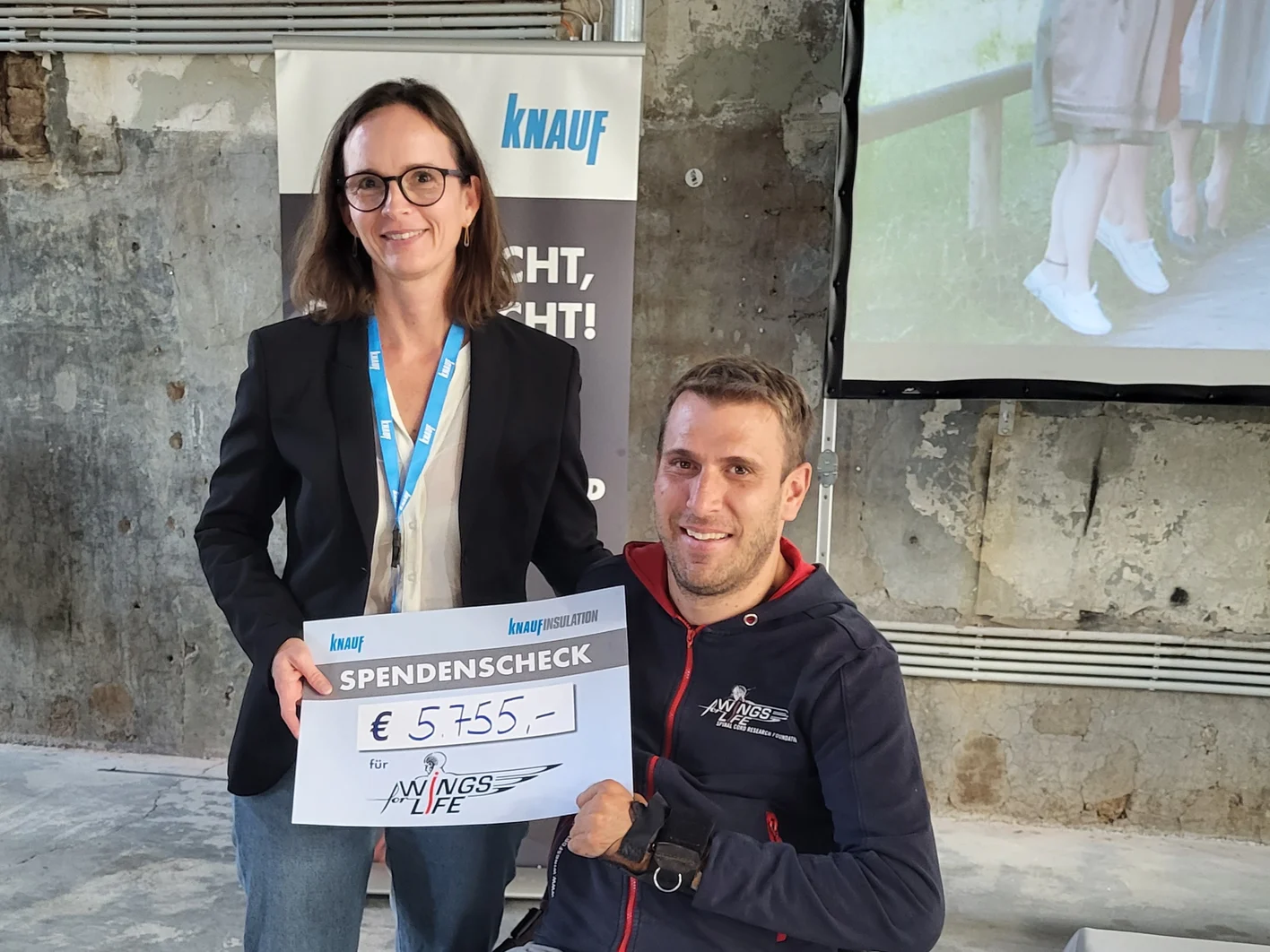 Mag. Ingrid Janker überreichte Mag. Wolfgang Illek von Wings for Life einen Scheck in der Höhe von 5755,— Euro