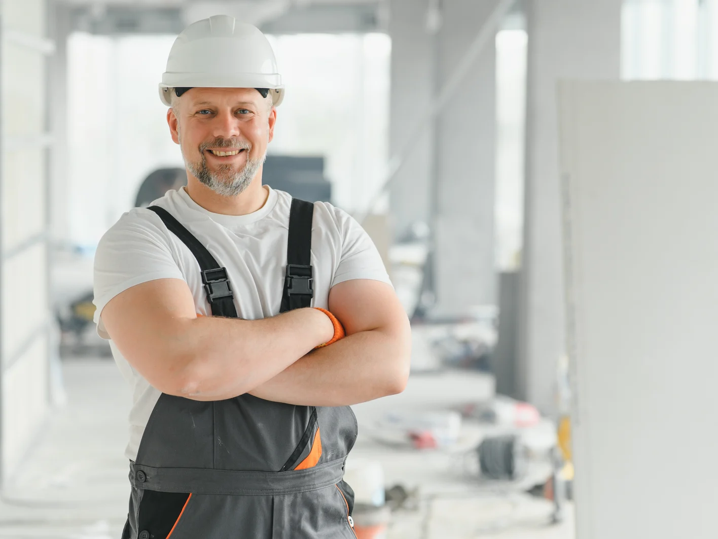 Portrait of a builder in the process of working on a construction site indoors