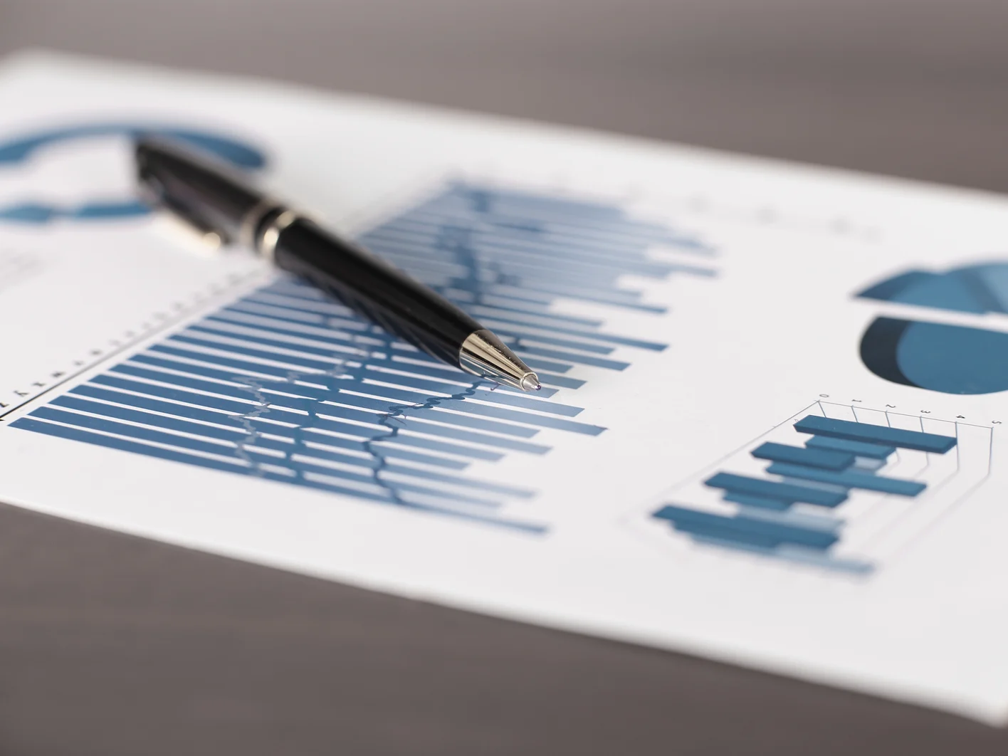 business background.a pen and a sheet with a financial report on