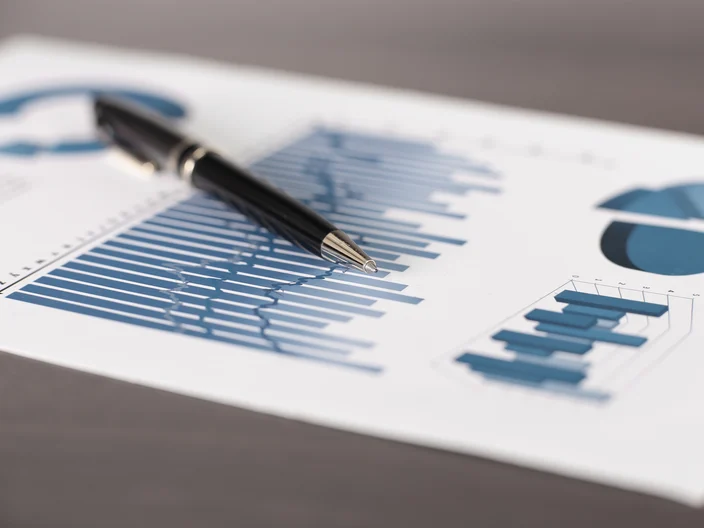 business background.a pen and a sheet with a financial report on the table