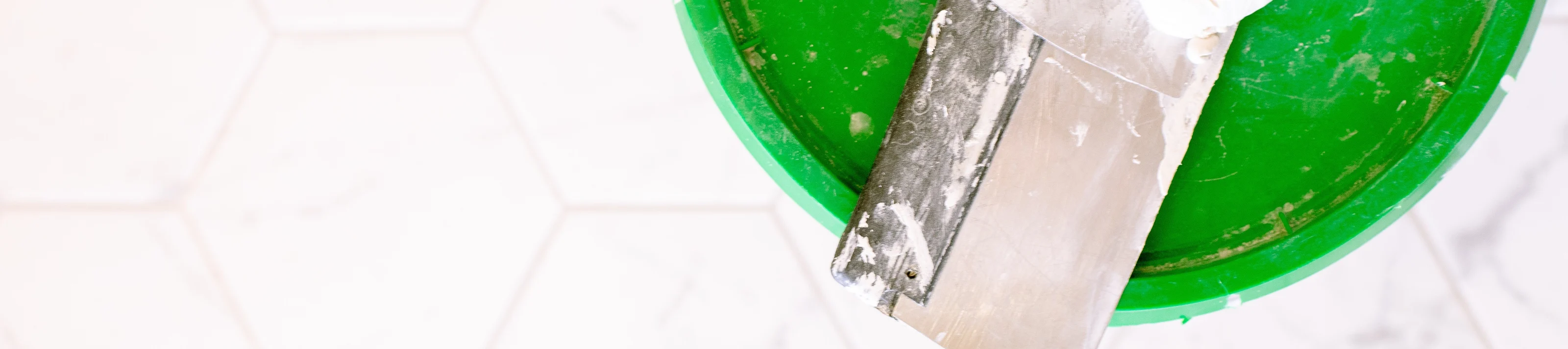 Eimer mit Pinsel auf Fliesen