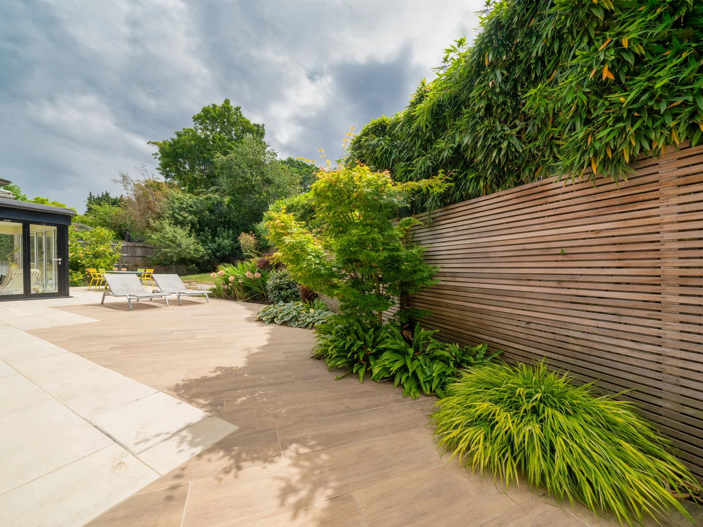 designer patio and garden with loungers and plants