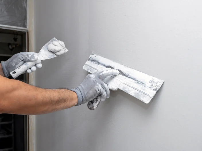 Plasterer applies plaster on the wall during repair and restoration work