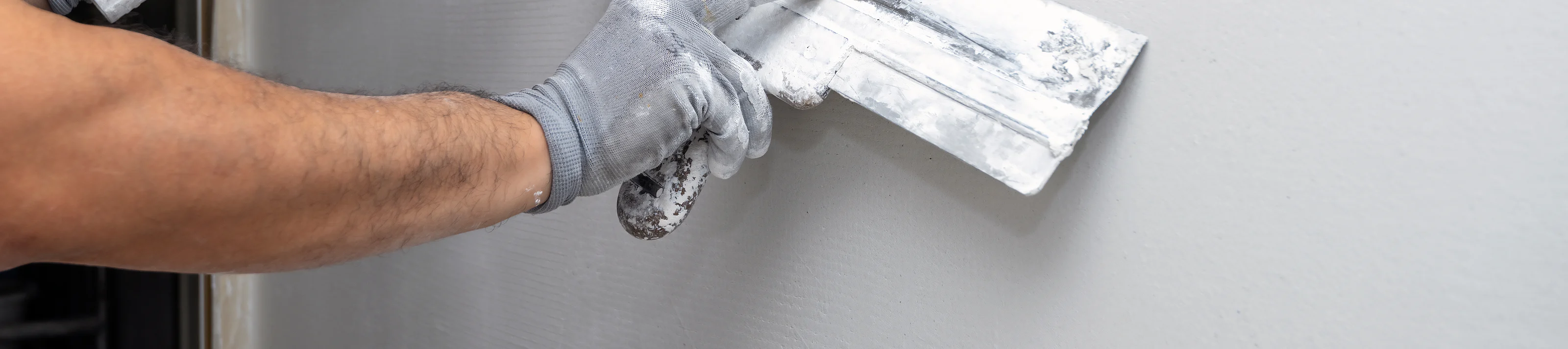 Plasterer applies plaster on the wall during repair and restoration work