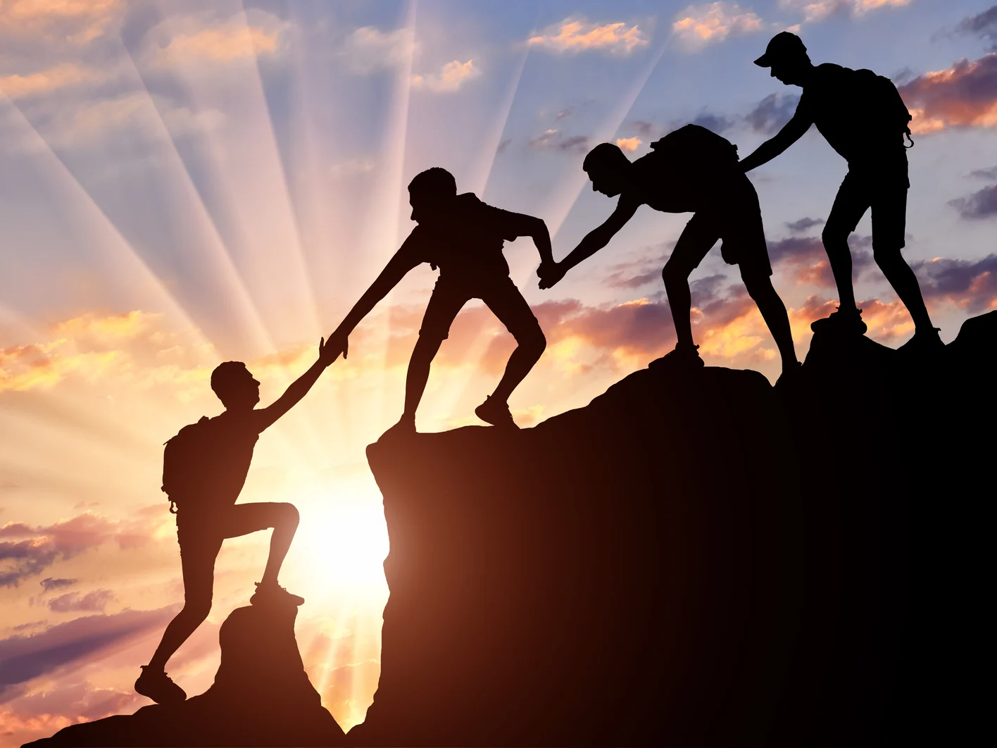 Men climbers help each other in the mountains
