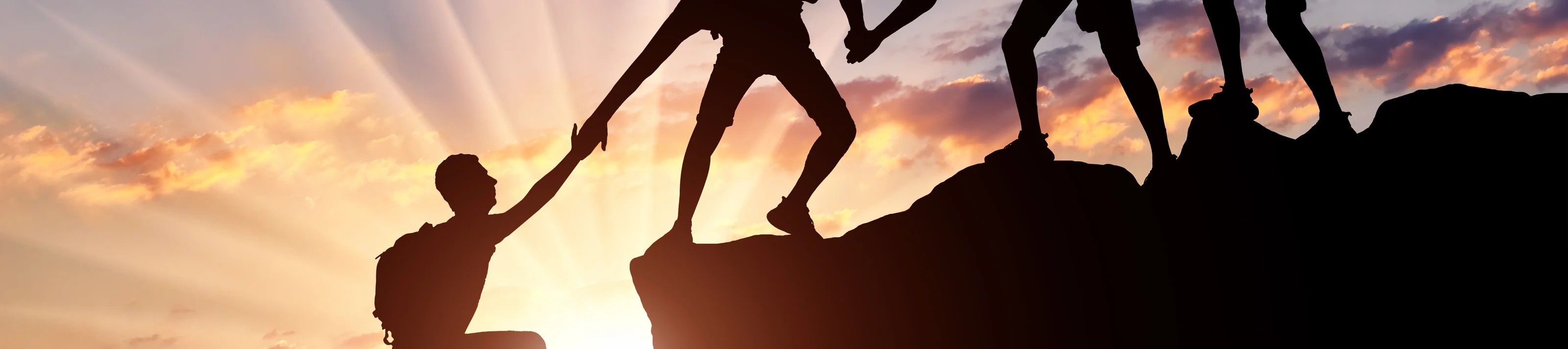 Men climbers help each other in the mountains