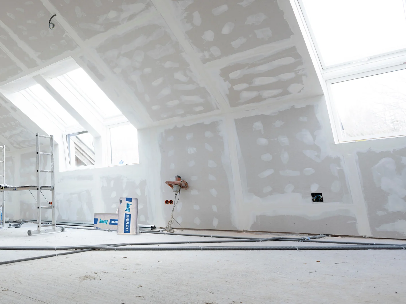Attic finishing construction site in the phase drywall spackling and plastering before screeding