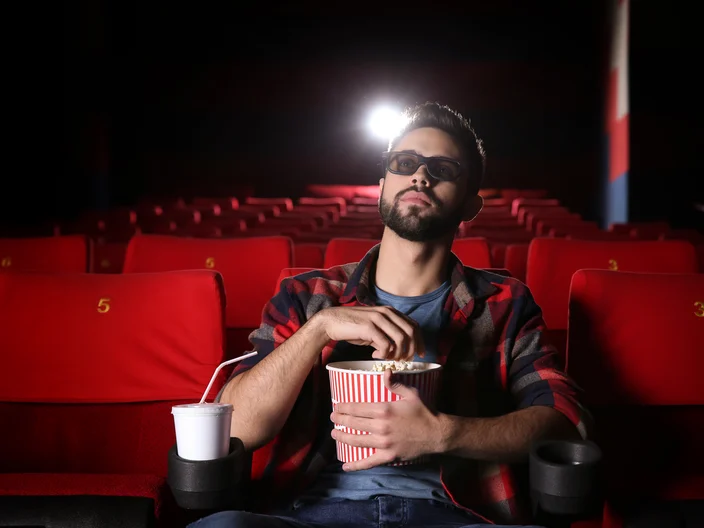 Young man watching movie in cinema