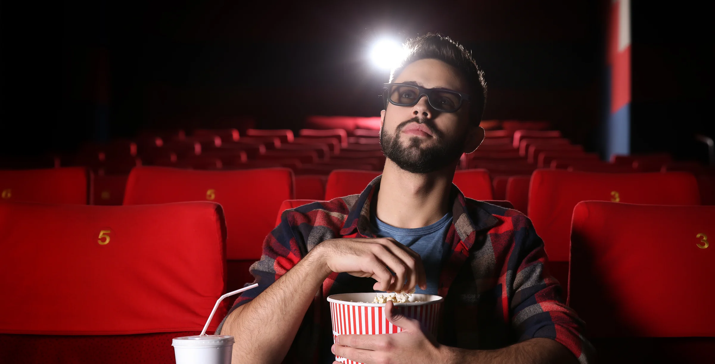 Young man watching movie in cinema
