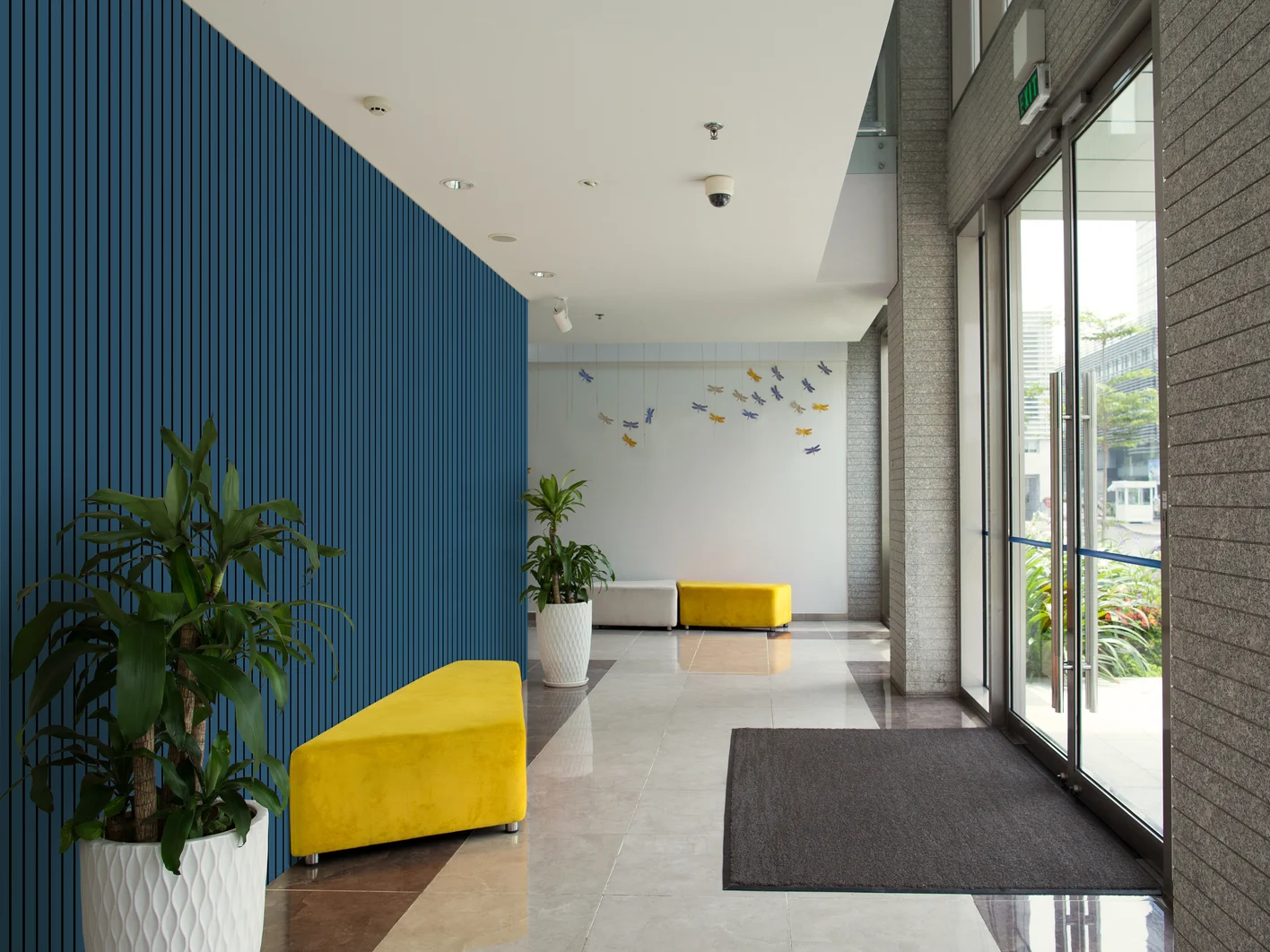 Eingang eines Gebäudes mit blauer Cleaneo Stripe an der Wand