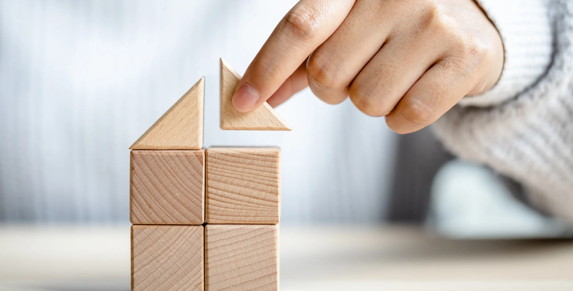 putting triangle wooden block for show the construction of a wooden in the shape of a hous