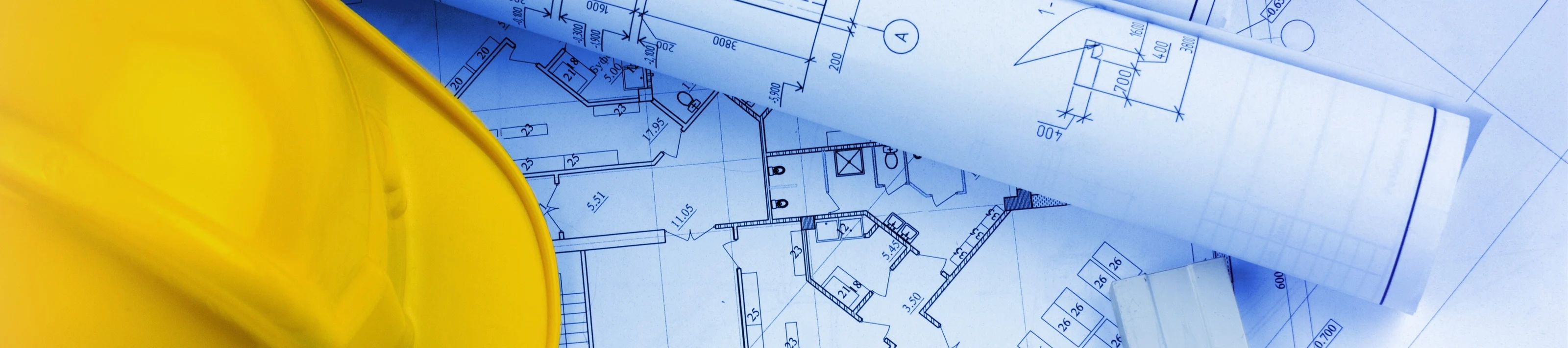 Blueprints construction and a yellow hardhat with a compass