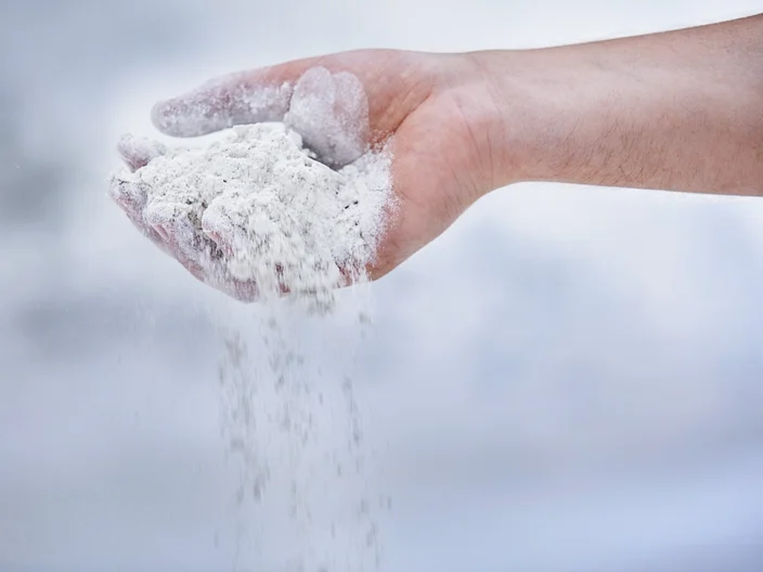 Gipspulver rieselt aus Hand