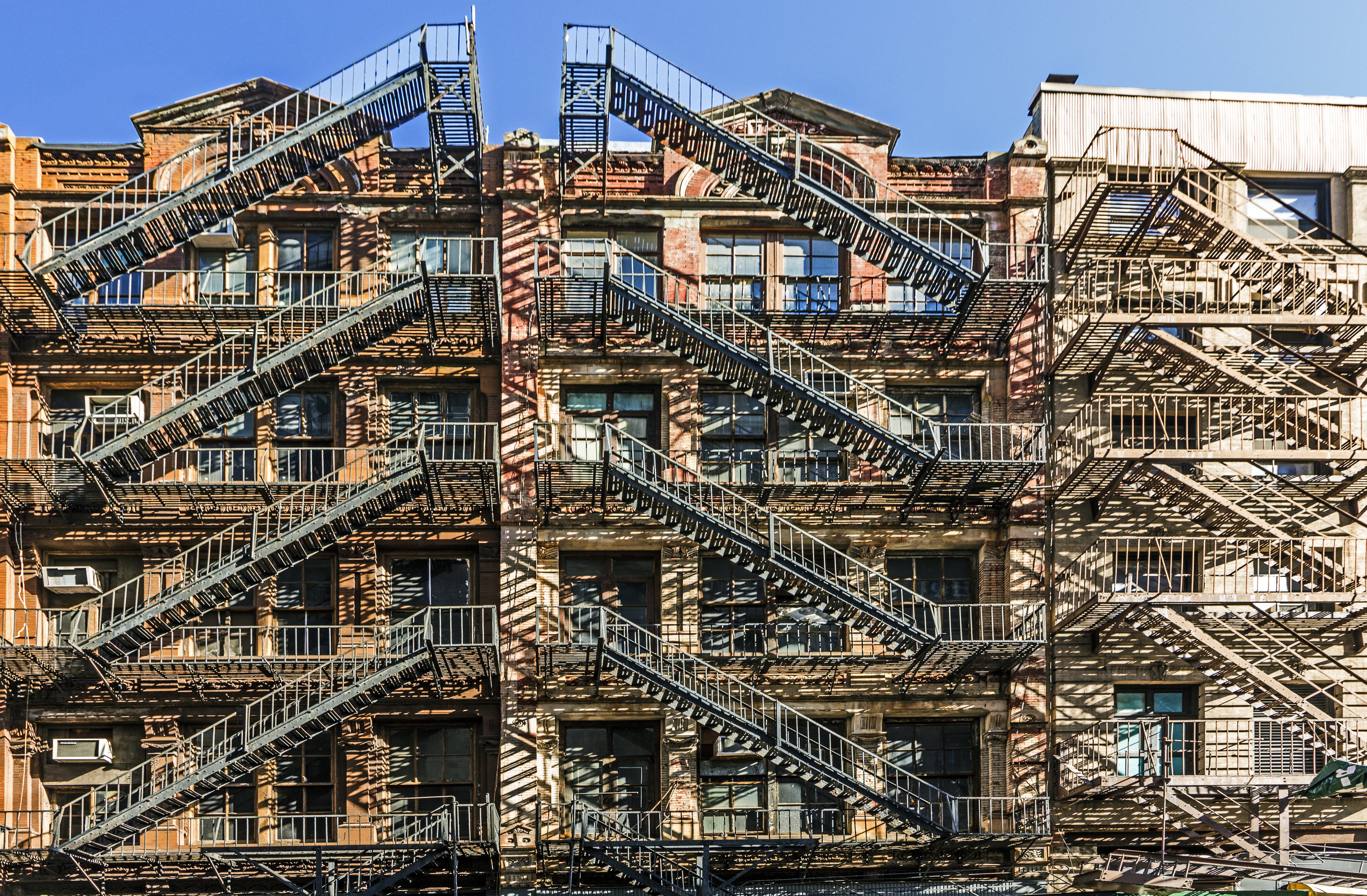 facade of old brick houses i NEw York with iron fire laders