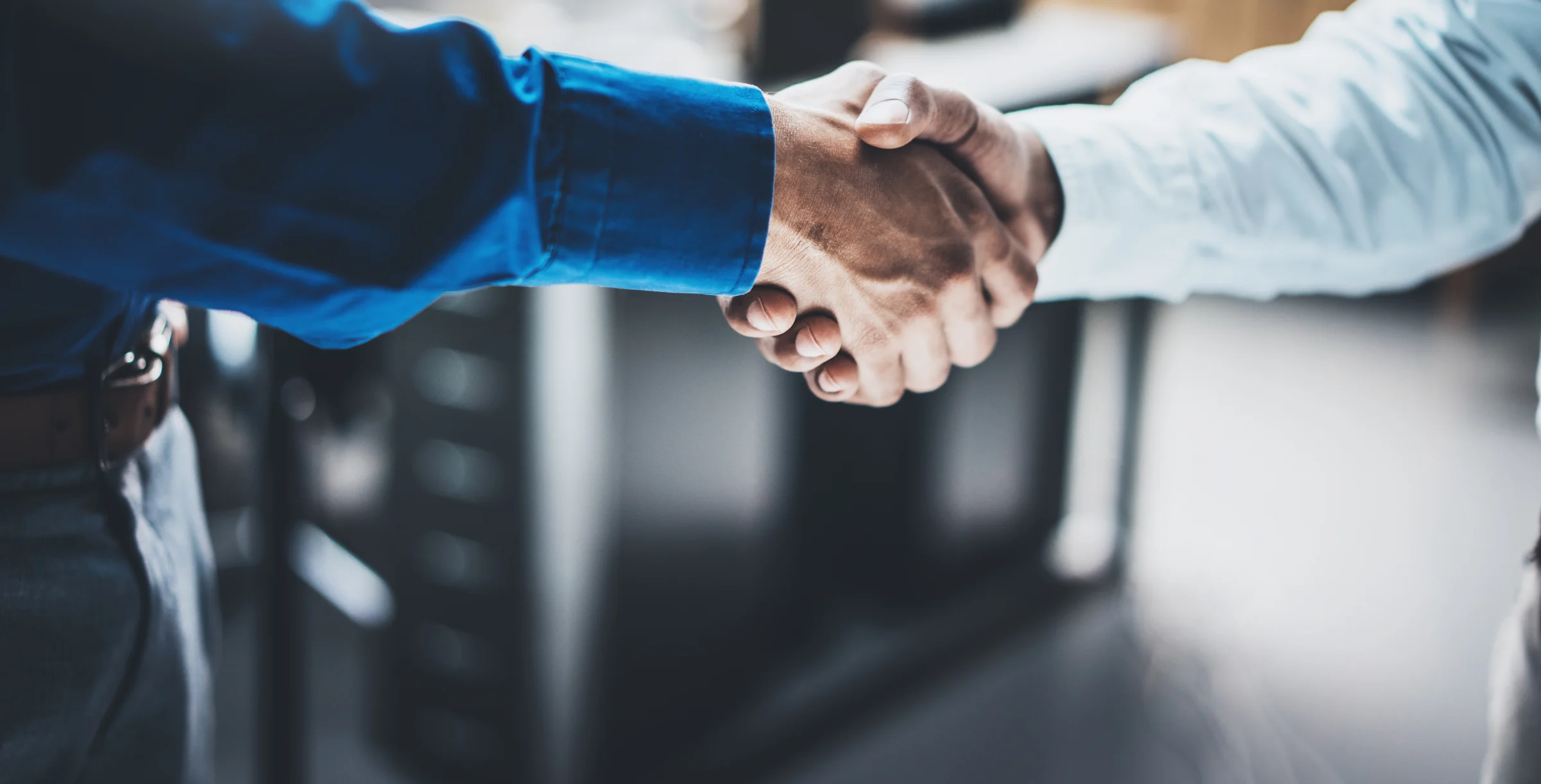 Business partnership handshake concept.Closeup photo of two businessmans handshaking process.Successful deal after great meeting.Horizontal, blurred background.