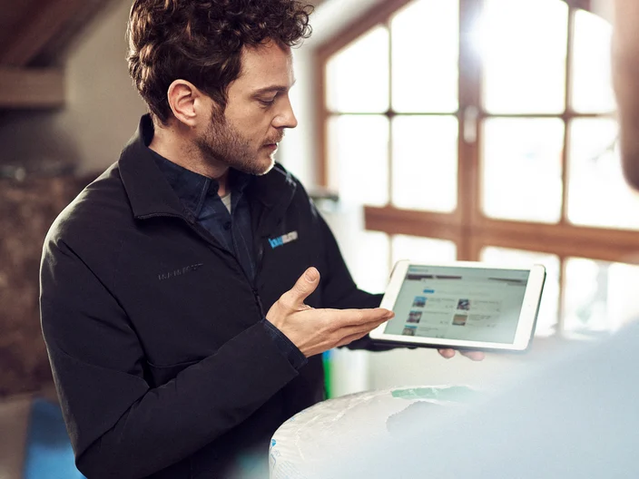 KI man holding ipad tools and services