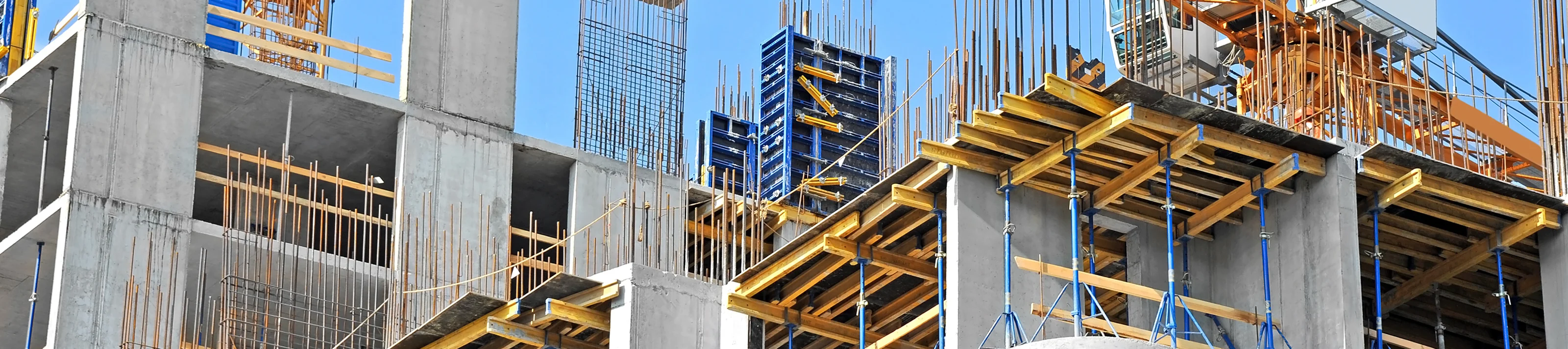 Crane and building construction site against blue sky