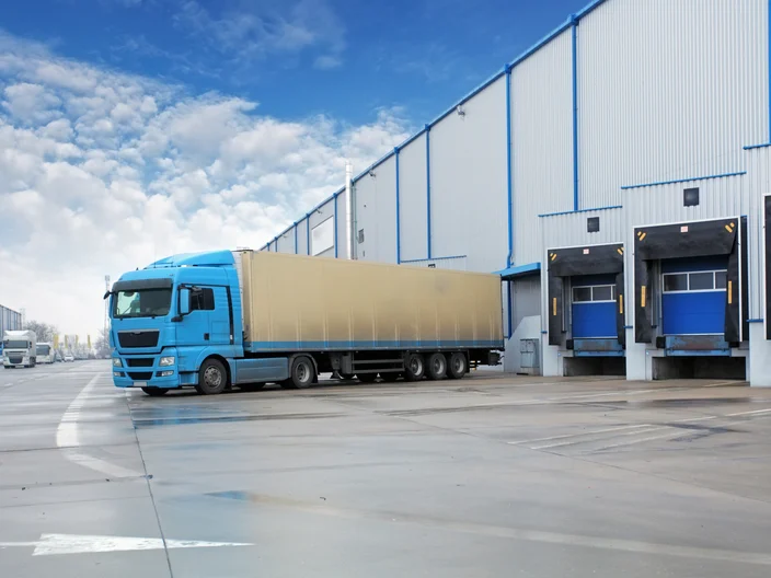 Unloading cargo truck at warehouse building