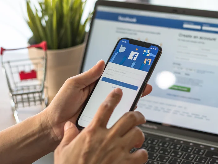 BANGKOK, THAILAND - May 2, 2018: Facebook social media app logo on log-in, sign-up registration page on mobile app screen on iPhone X (10) in person's hand working on e-commerce shopping business