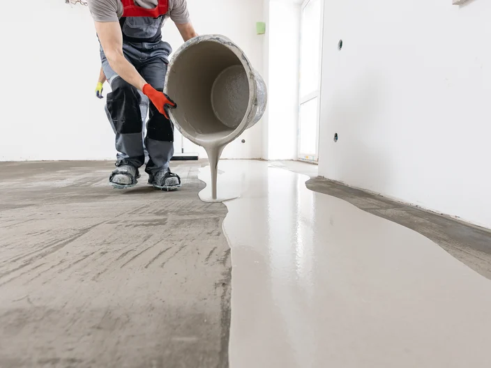 Worker use screed concrete epoxy for level. Leveling with mixture of cement for floors