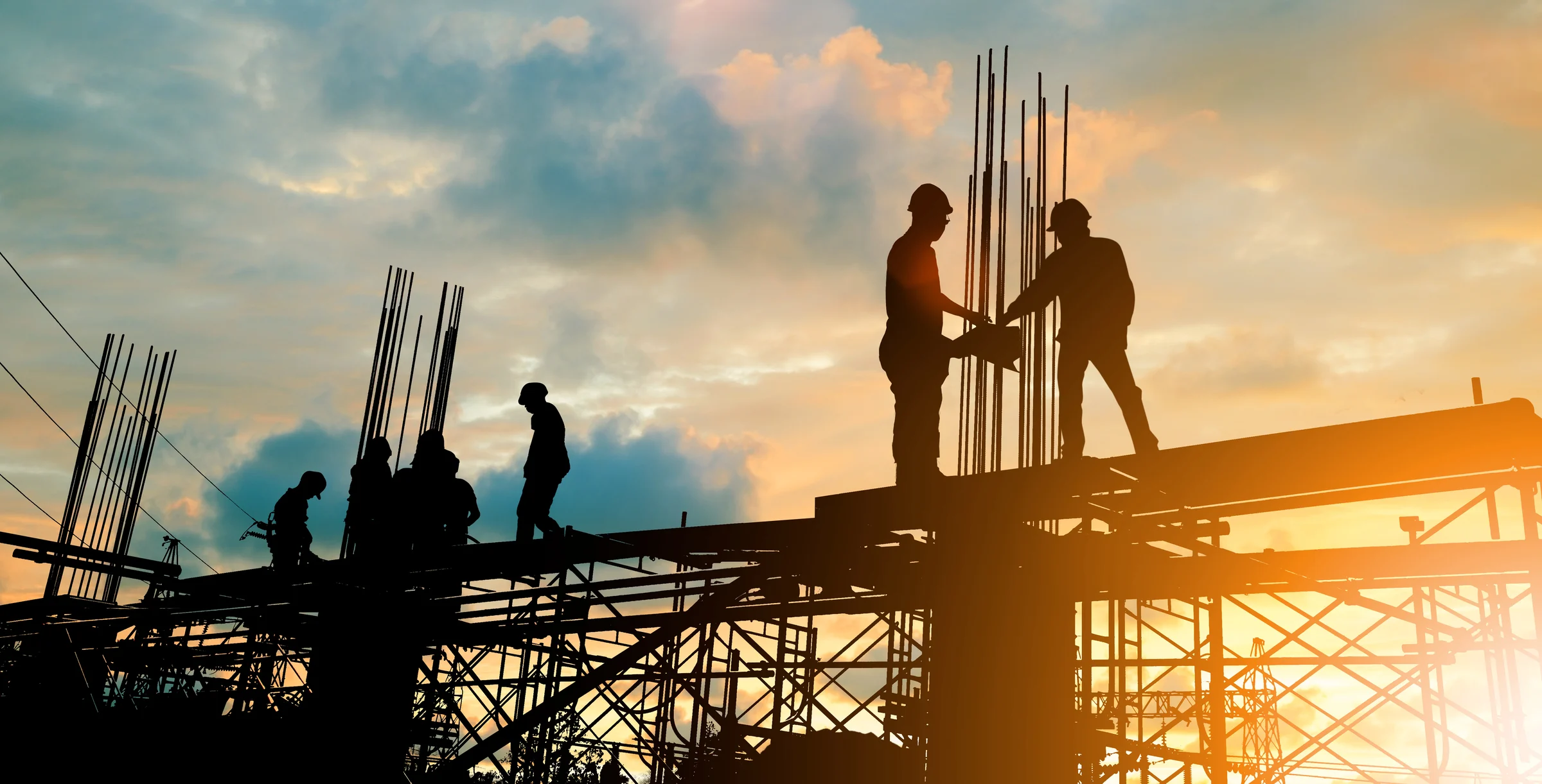 Silhouette of engineer and construction team working at site over blurred background sunset pastel for industry background with Light fair.