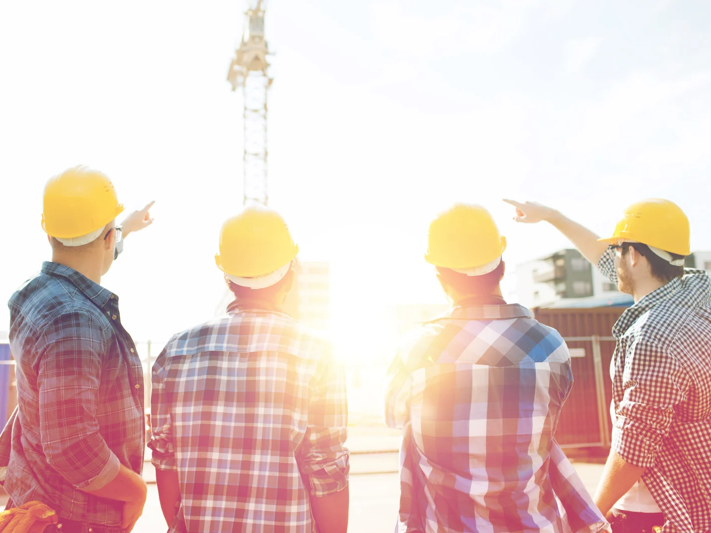 group of builders in hardhats at construction site