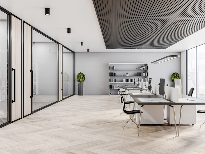 Modern sunny open space office design with glass walls along the corridor, computers, city view windows, white walls and wooden floor