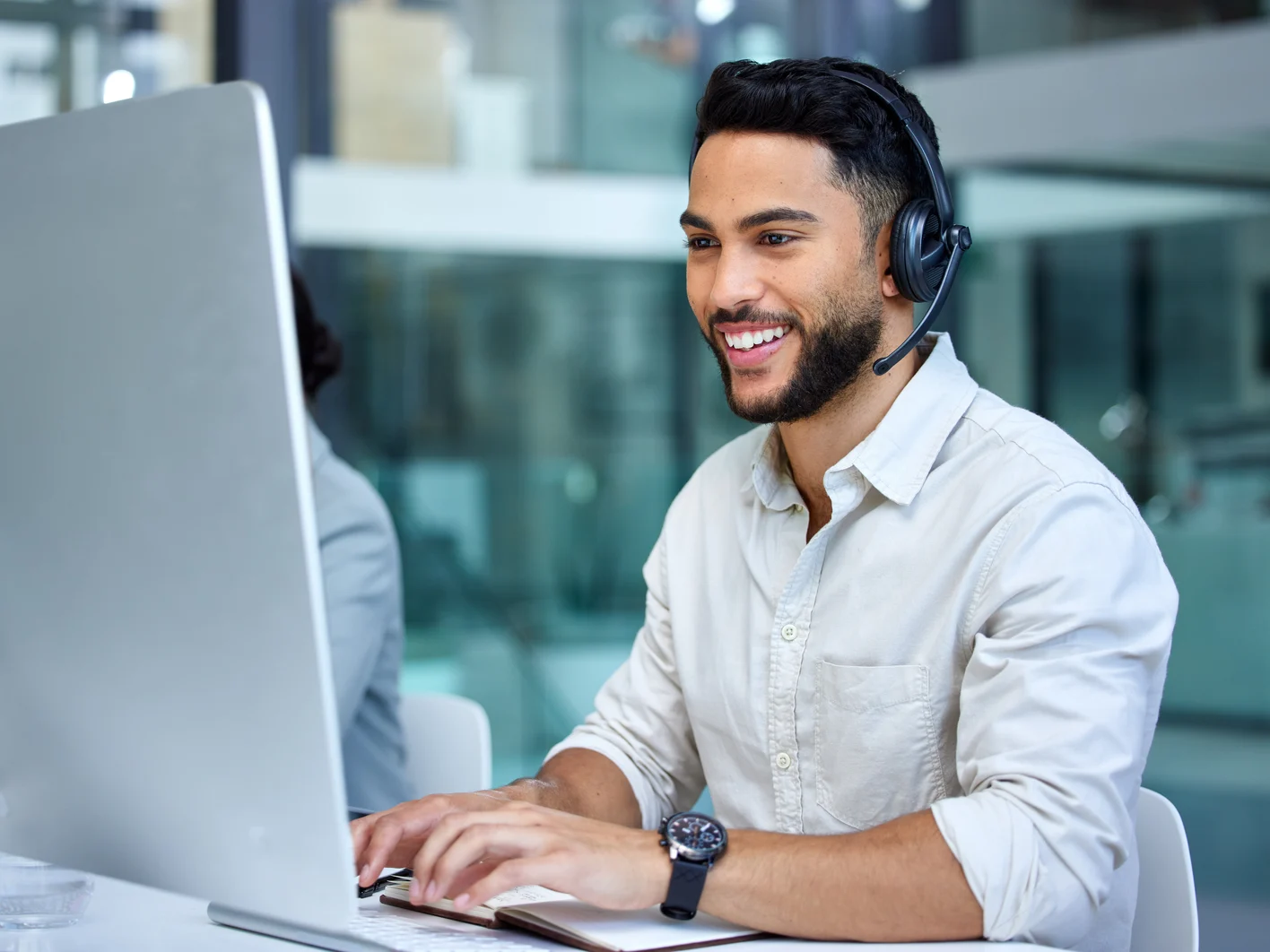 Business man call center and web support communication at a computer in a office Phone conversation smile and male worker with contact us, crm and customer service job in a consulting agency