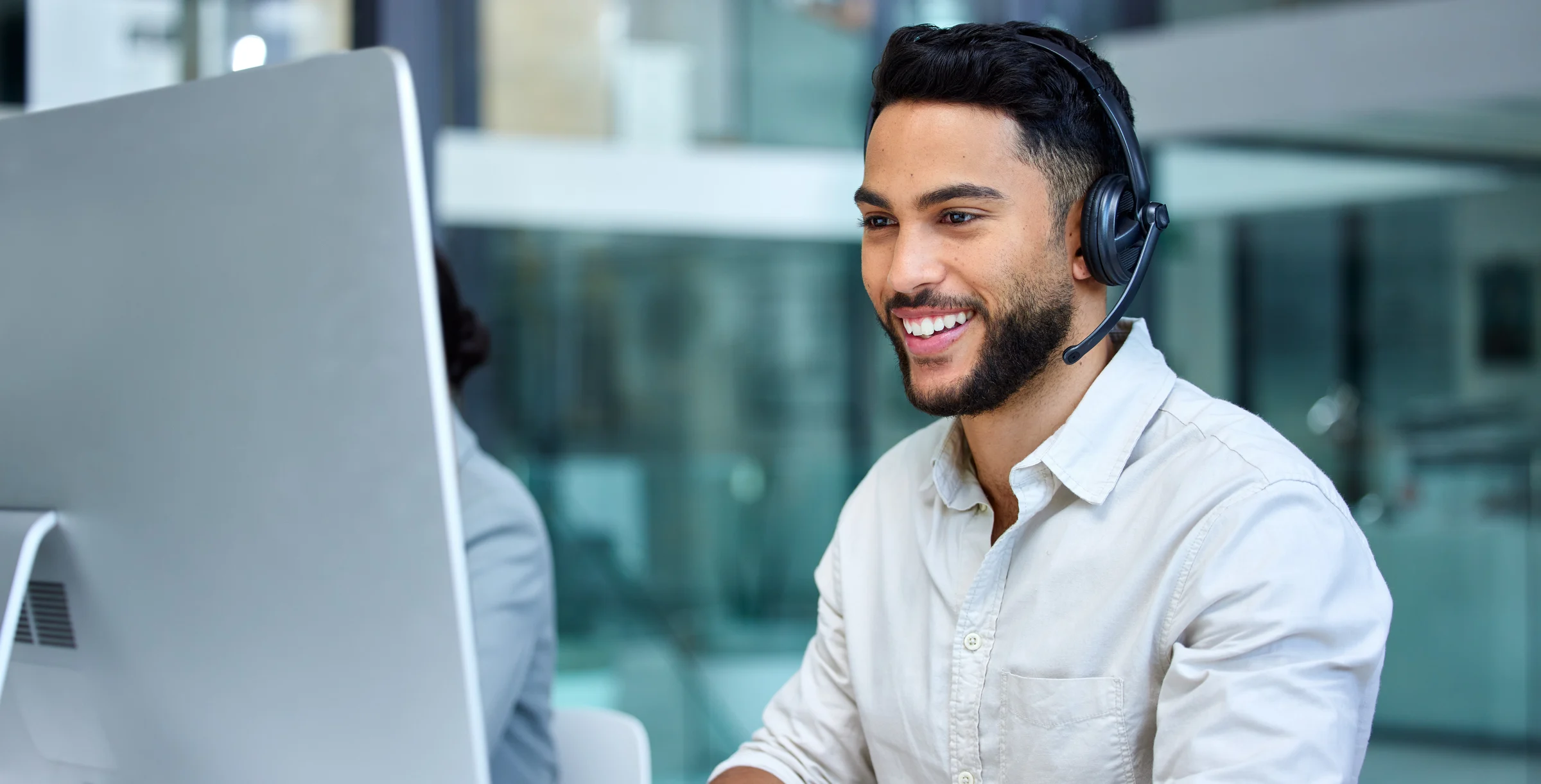 Business man, call center and web support communication at a computer in a office. Phone conversation, smile and male worker with contact us, crm and customer service job in a consulting agency