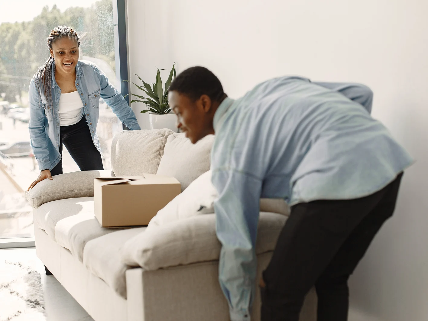 Couple with boxes moving into new home smiling