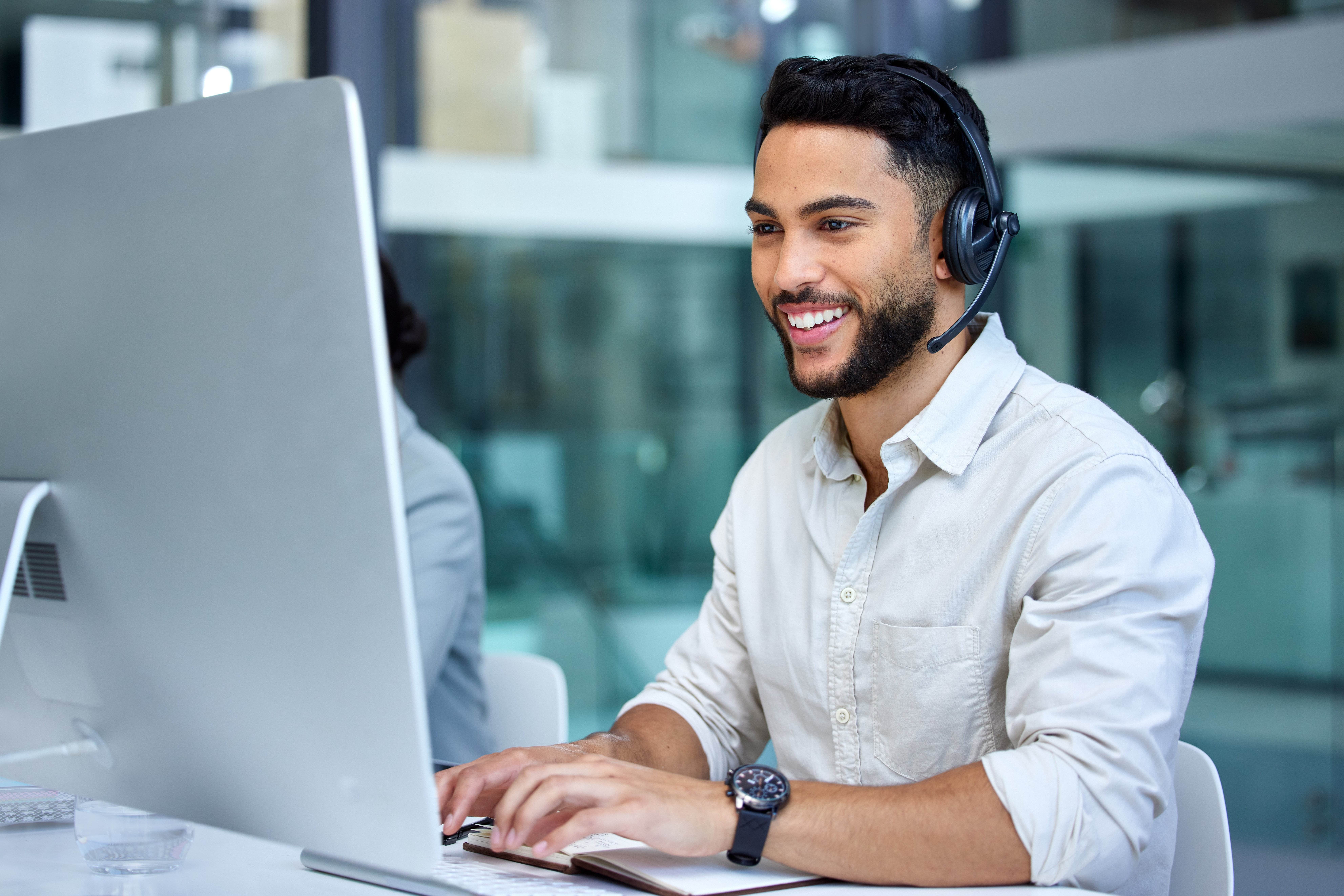 Mitarbeiter am Computer mit Headset