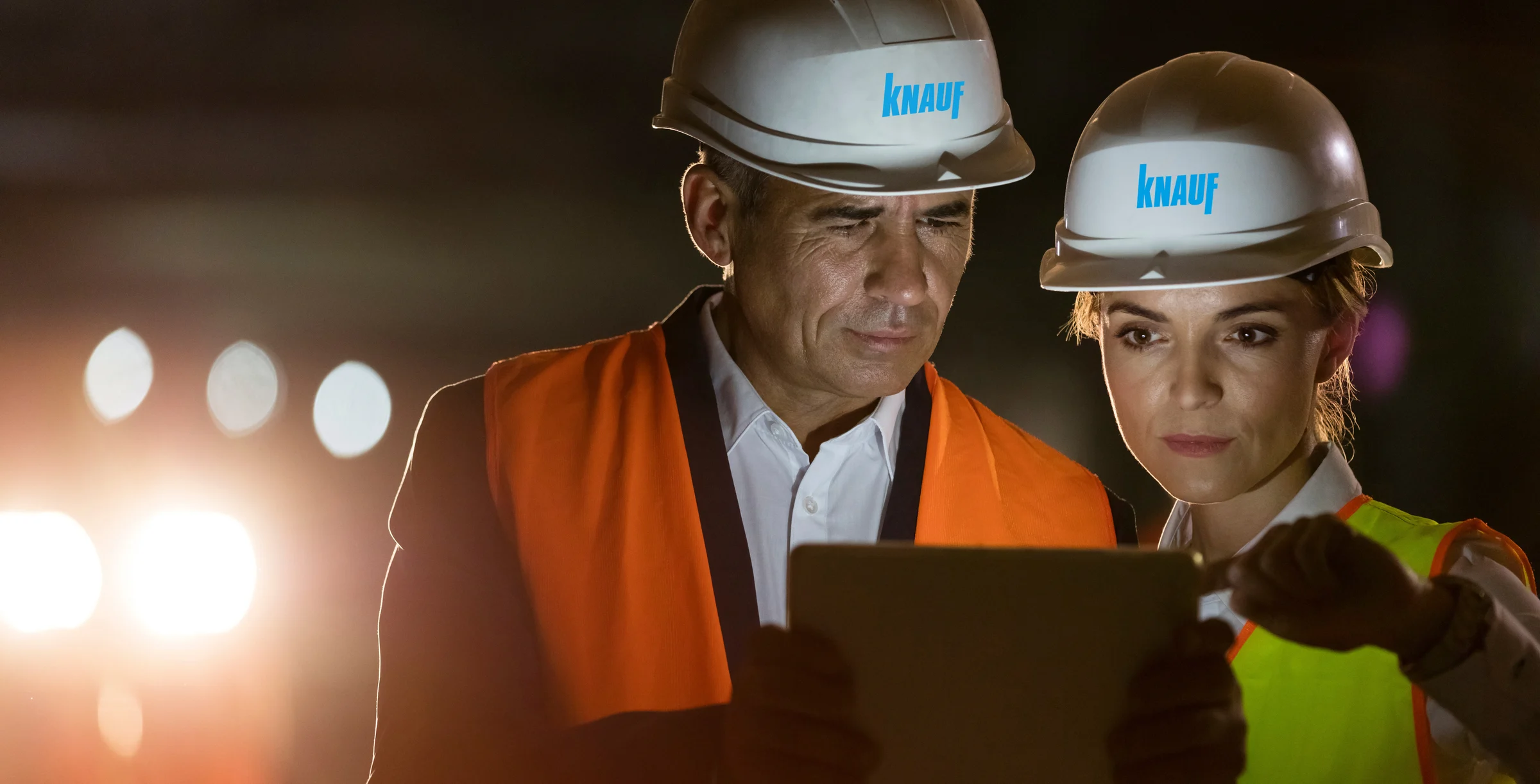 Construction worker engineer using digital tablet at dark construction site