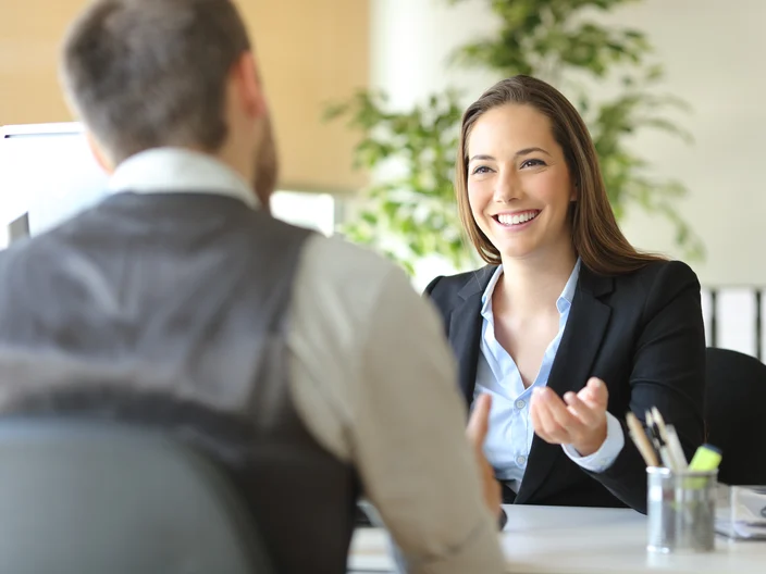 Happy executive coworkers laughing and talking at the office